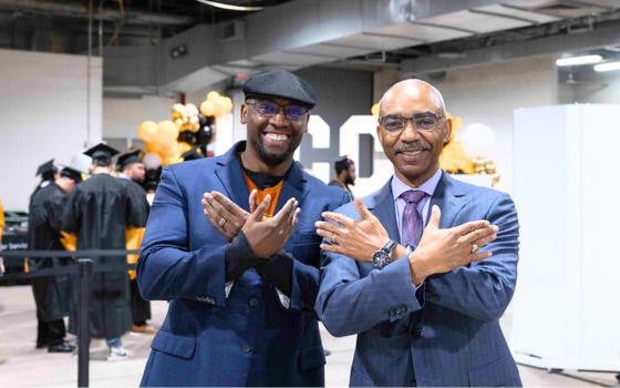 HCC Alumni proudly showing off the Swoop Eagle hand sign