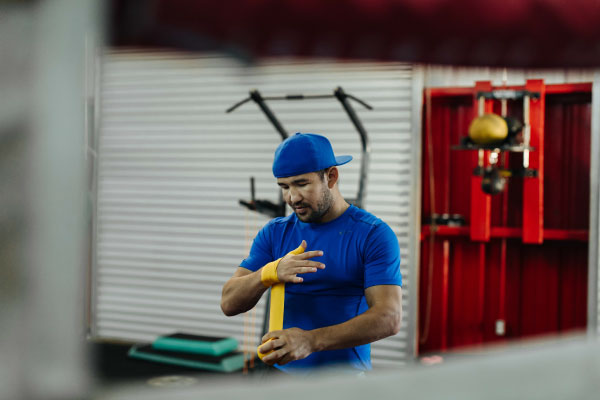 Male student athlete wrapping his wrists to box